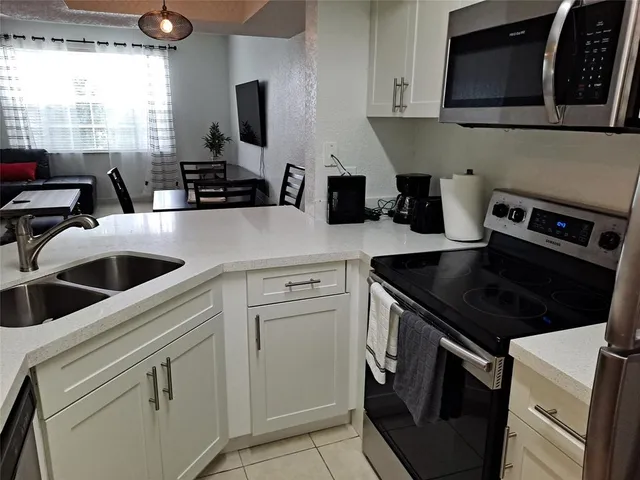 a kitchen with white cabinets and black appliances