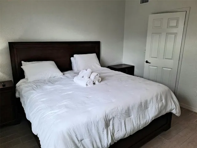 a large bed sitting in a bedroom next to a cabinet