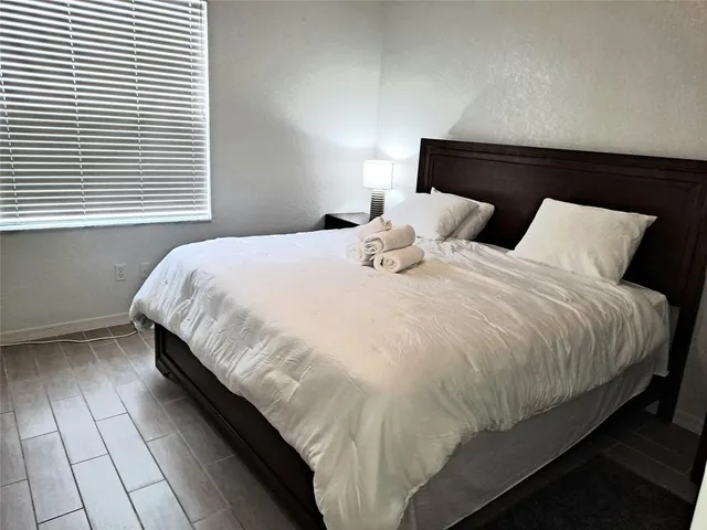 a large bed sitting in a bedroom next to a window