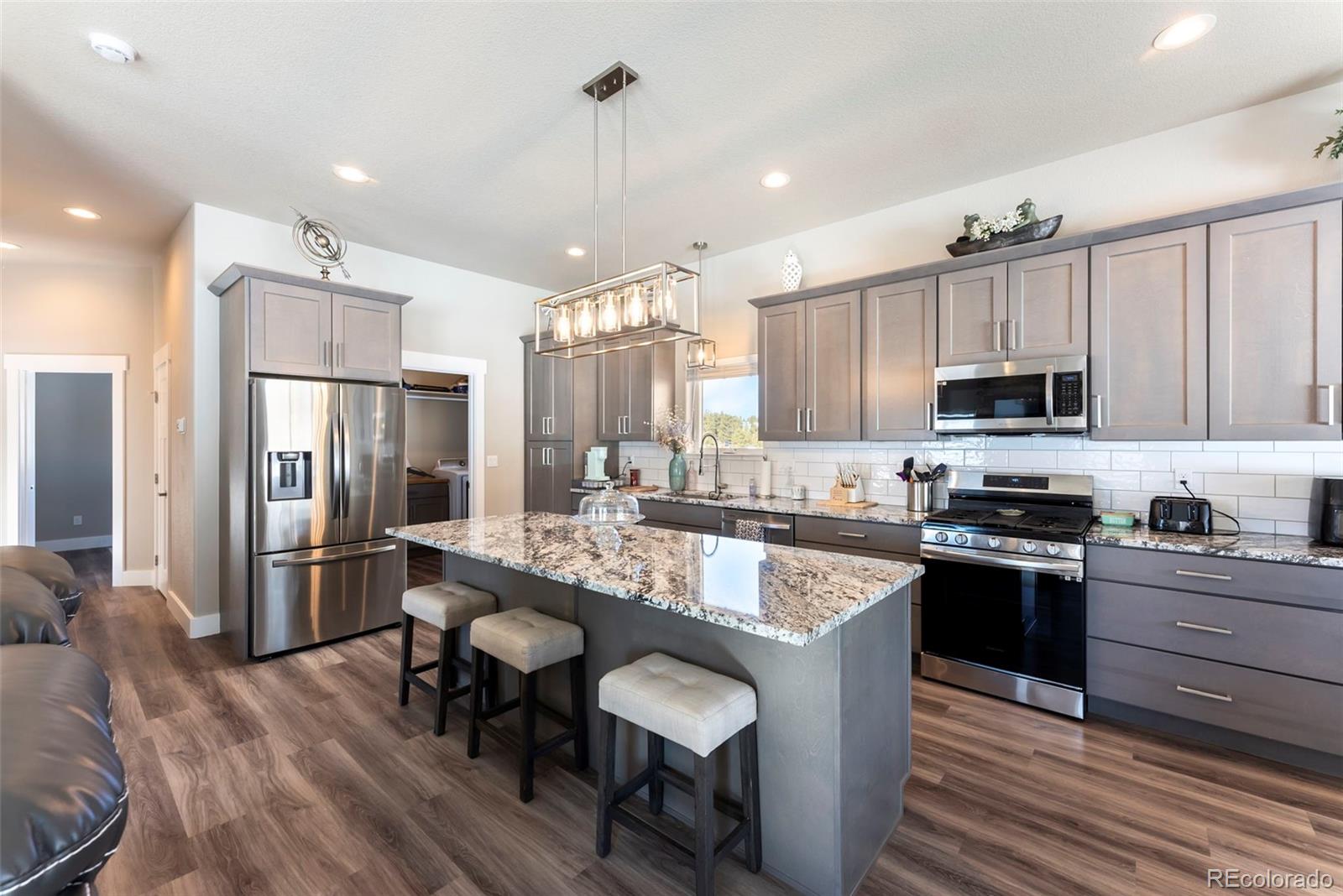 489 Duesouth Road Florissant, CO 80816 - Photo 6 of 40 a kitchen with granite countertop kitchen island wooden cabinets and stainless steel appliances