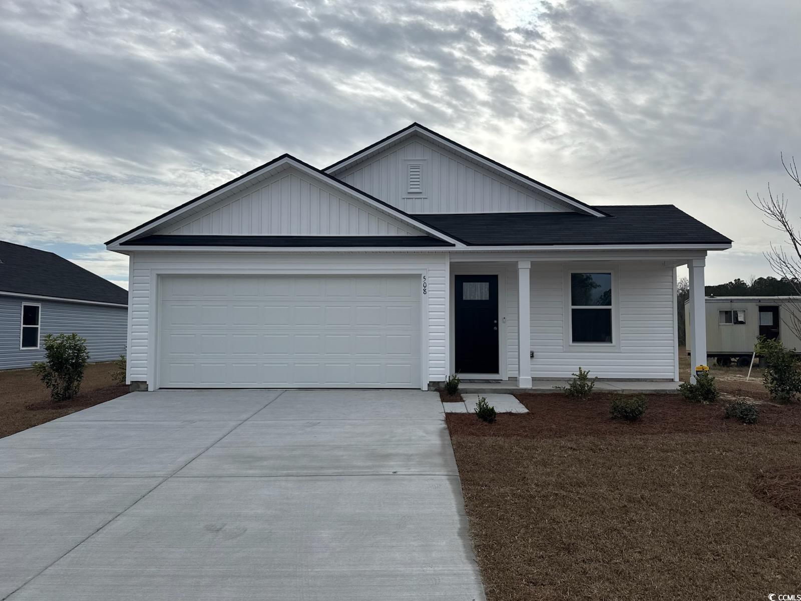 508 Runaway Train Drive Loris, SC 29569 - Photo 1 of 20 Ranch-style house featuring board and batten siding, a porch, concrete driveway, and a garage