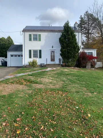 a front view of a house with a garden
