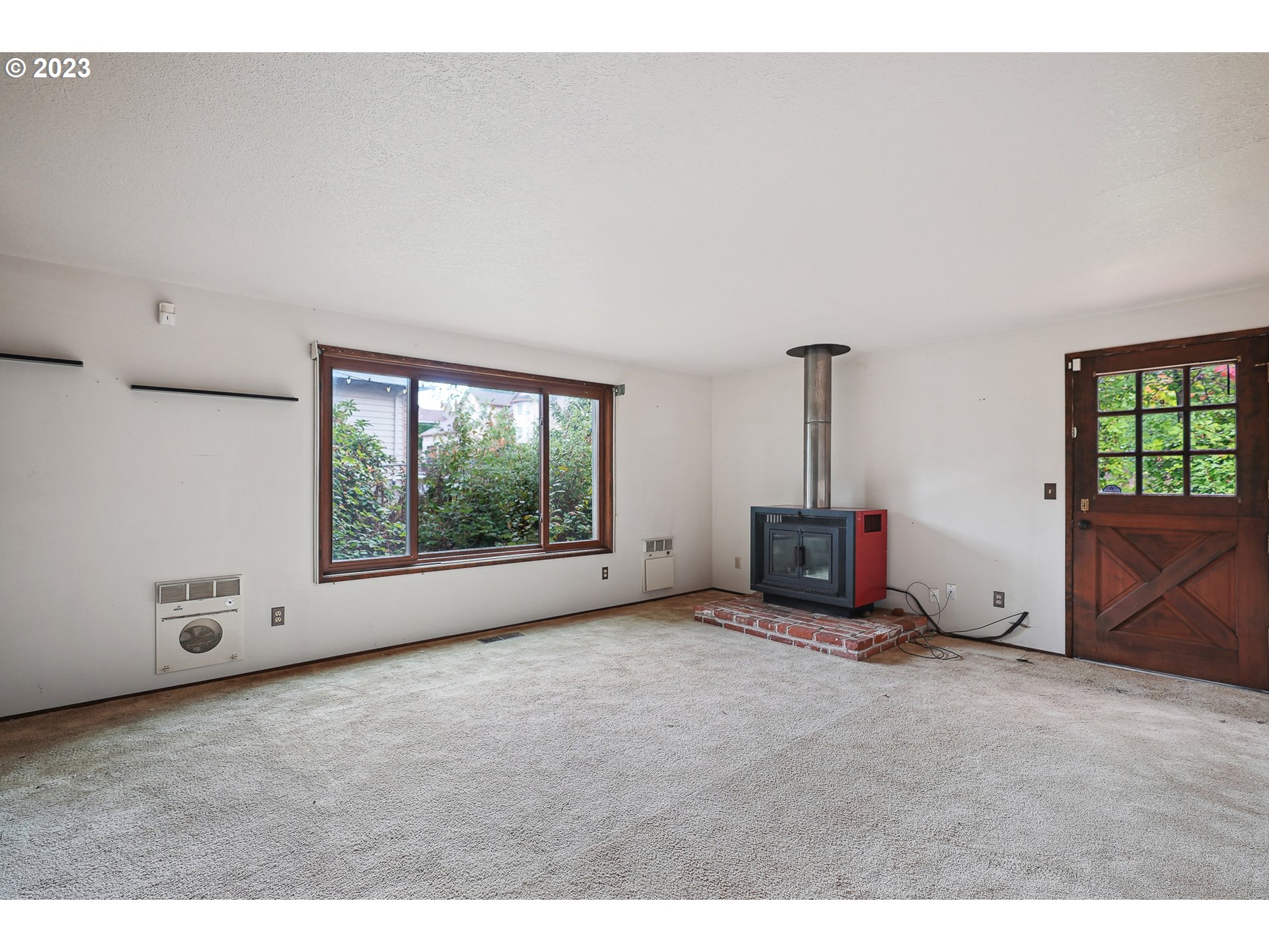 2295 Northeast Juniper Avenue Gresham, OR 97030 - Photo 2 of 25 a view of an empty room with a fireplace and a window