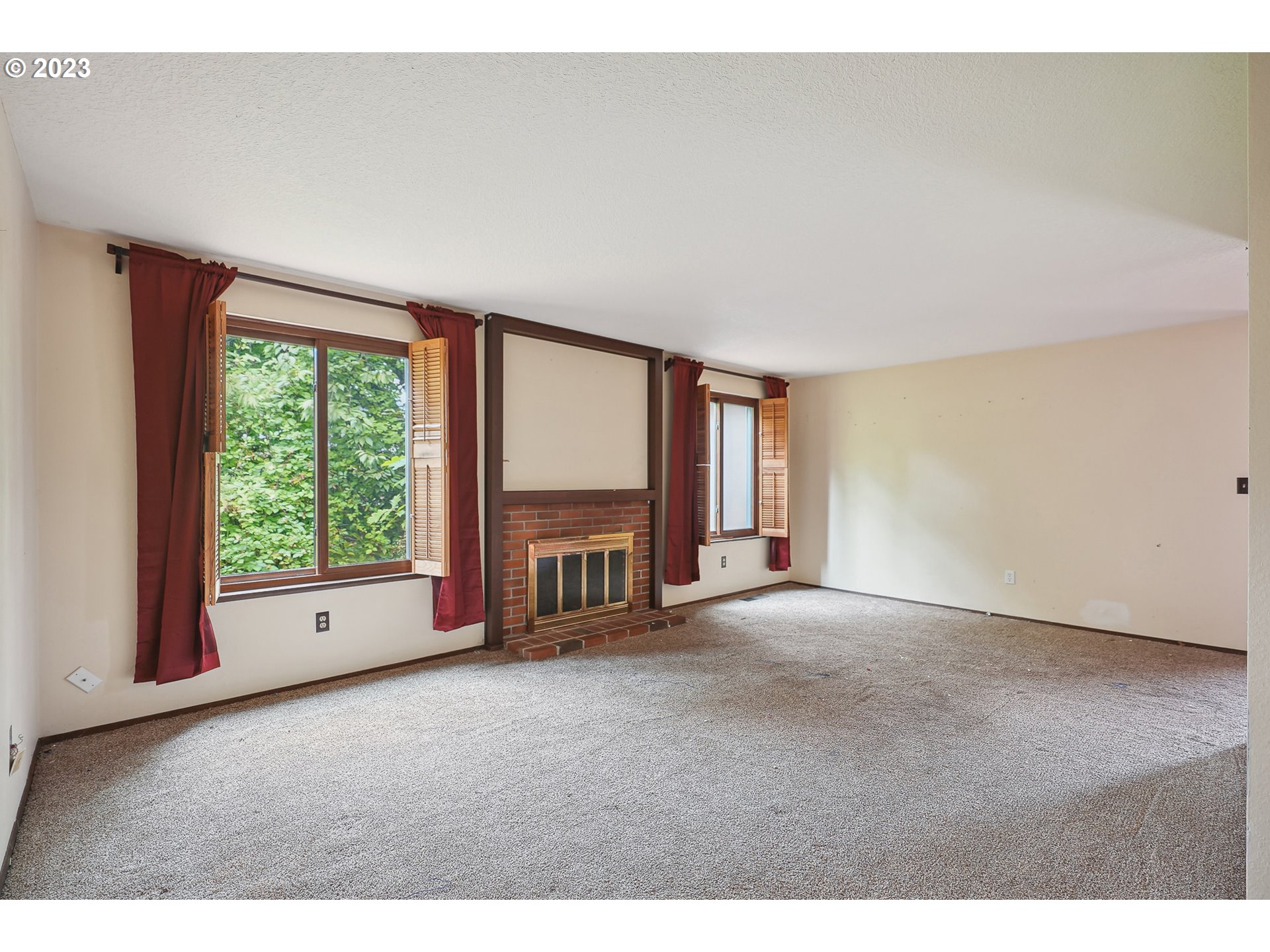 2295 Northeast Juniper Avenue Gresham, OR 97030 - Photo 3 of 25 a view of an empty room with a fireplace and a large window