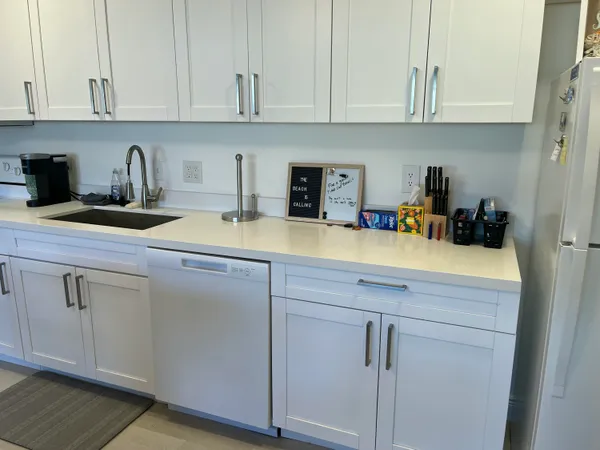 a kitchen with cabinets appliances a sink and a counter top space