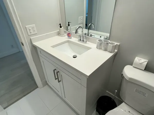 a bathroom with a sink a toilet and a mirror