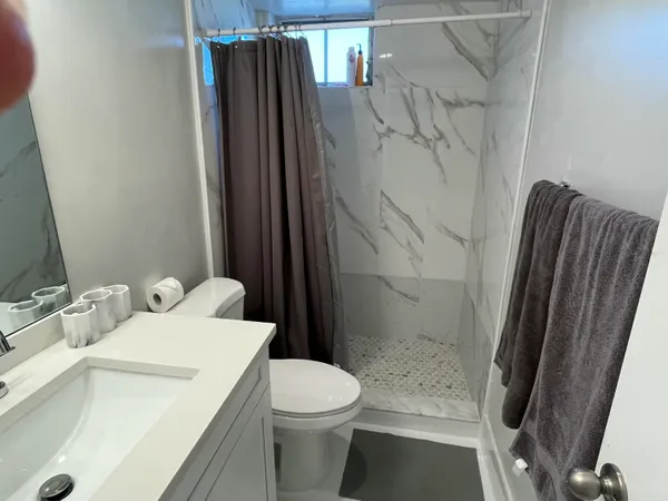 a bathroom with a sink toilet and shower