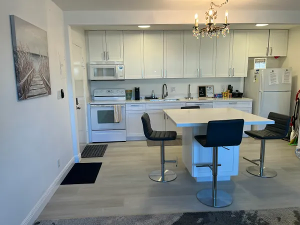 a kitchen with stainless steel appliances granite countertop a sink and a refrigerator