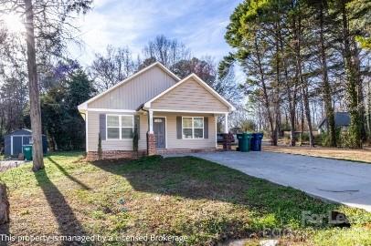 100 Henson Street Albemarle, NC 28001 - Photo 2 of 24 a front view of a house with a garden and trees