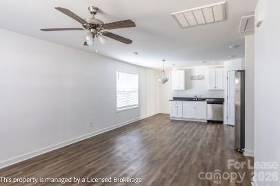 100 Henson Street Albemarle, NC 28001 - Photo 5 of 24 a view of a kitchen with a sink dishwasher a refrigerator with white cabinets and wooden floor