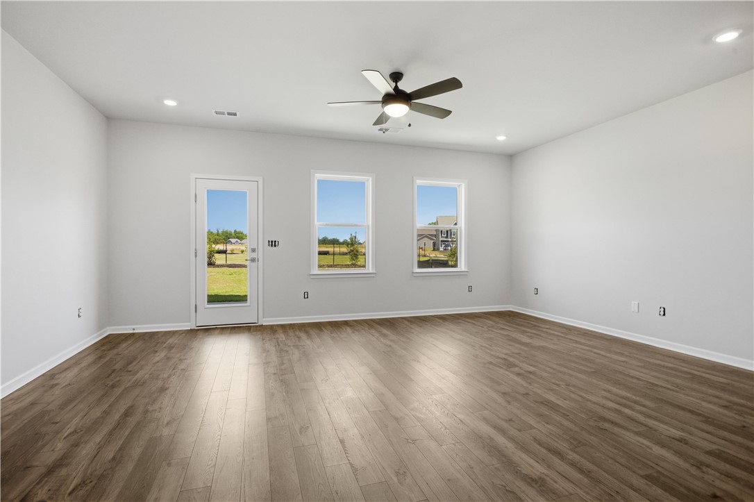 552 Hydrangea Street, Unit LOT 66 Seneca, SC 29678 - Photo 11 of 31 Ample natural light illuminates this spacious living area with resilient wood-look flooring and a modern ceiling fan.