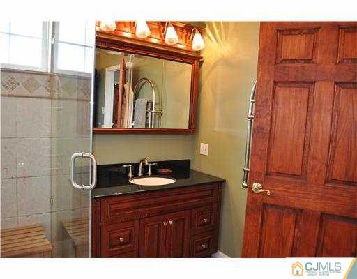 24 Sunflower Road Somerset, NJ 08873 - Photo 11 of 15 a bathroom with a sink a mirror and vanity