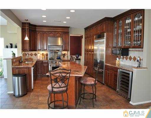 24 Sunflower Road Somerset, NJ 08873 - Photo 3 of 15 a kitchen with stainless steel appliances granite countertop a stove top oven a refrigerator a sink and dining table with wooden floor