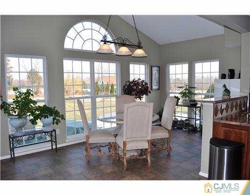 24 Sunflower Road Somerset, NJ 08873 - Photo 5 of 15 a dining room with wooden floor a chandelier a glass table and chairs