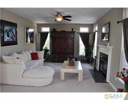 24 Sunflower Road Somerset, NJ 08873 - Photo 8 of 15 a living room with furniture a fireplace and a flat screen tv