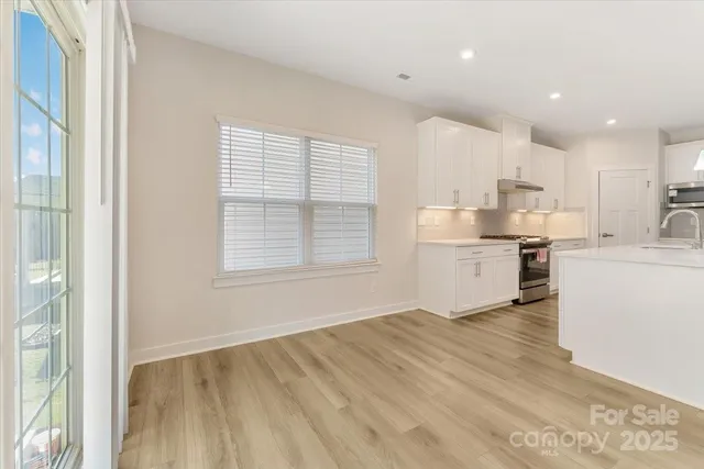 a view of kitchen with wooden floor and electronic appliances