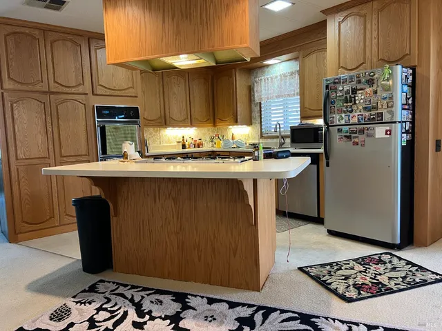 a kitchen with stainless steel appliances granite countertop a refrigerator and a stove