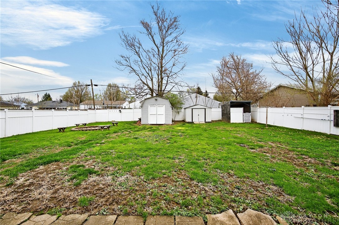 3301 Wildwood Road Middletown, OH 45042 - Photo 50 of 68 This spacious yard features a fire pit and multiple sheds, perfect for outdoor activities and storage.