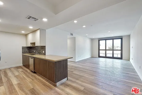 a kitchen with stainless steel appliances granite countertop a wooden cabinets a stove top oven and sink