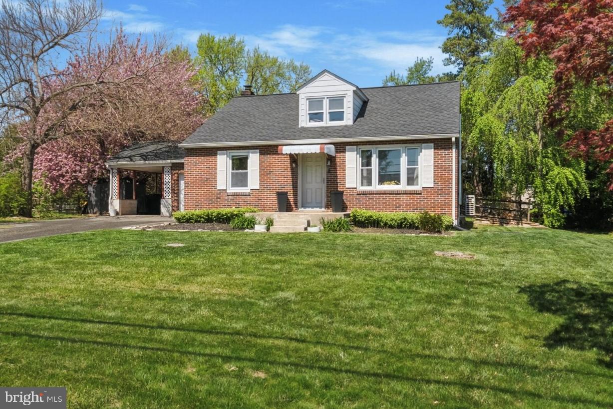 a front view of a house with a yard and trees