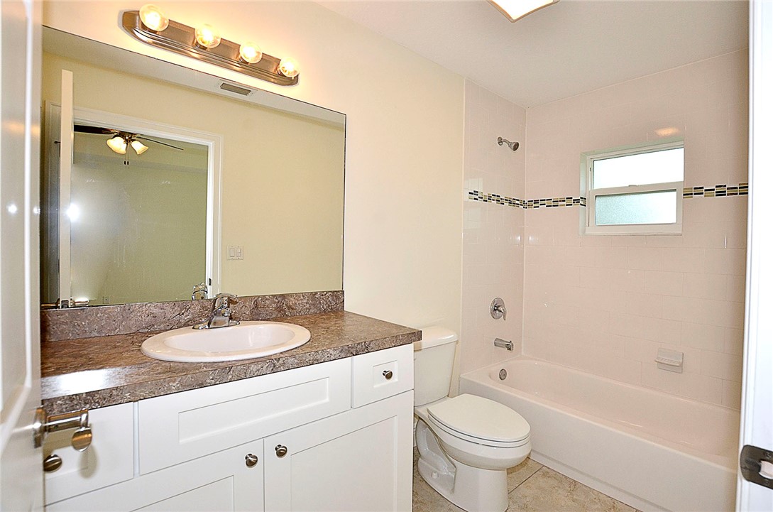 4899 Kirby Loop Road Fort Pierce, FL 34981 - Photo 14 of 32 a bathroom with a granite countertop sink toilet a mirror and shower