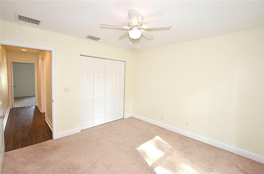 4899 Kirby Loop Road Fort Pierce, FL 34981 - Photo 17 of 32 a view of a big room with wooden floor and a chandelier fan