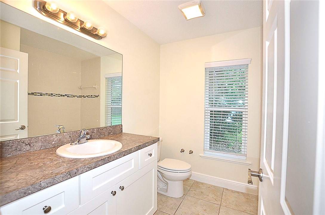 4899 Kirby Loop Road Fort Pierce, FL 34981 - Photo 22 of 32 a bathroom with a granite countertop sink toilet and shower
