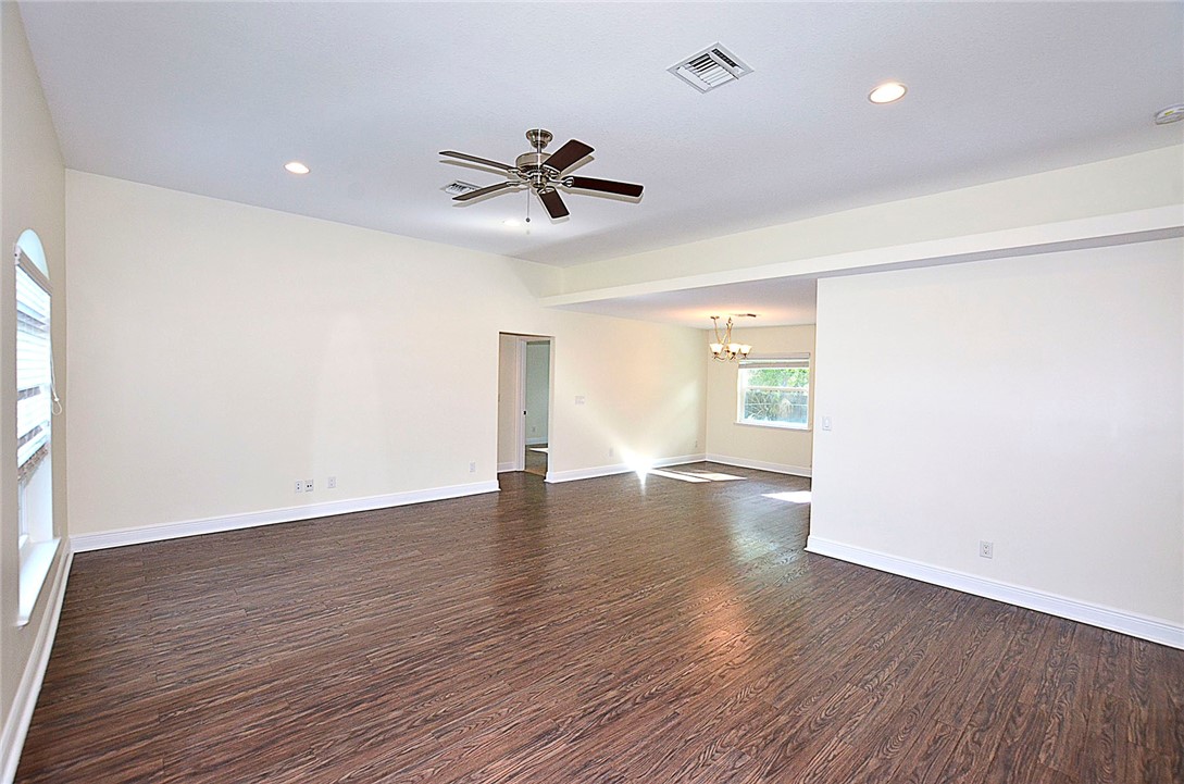 4899 Kirby Loop Road Fort Pierce, FL 34981 - Photo 3 of 32 a view of an empty room with wooden floor and a window
