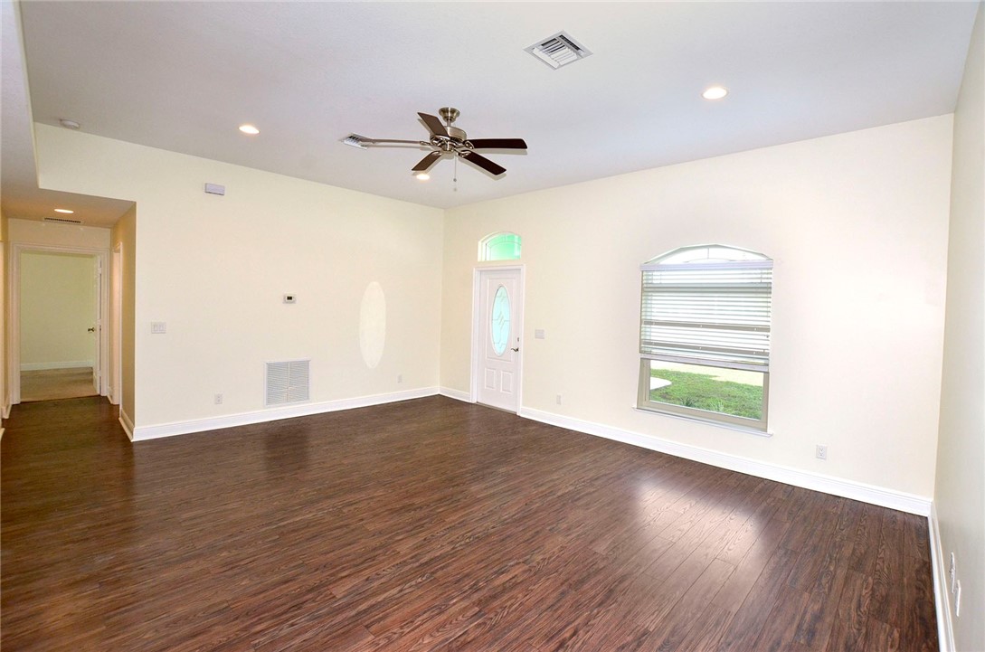4899 Kirby Loop Road Fort Pierce, FL 34981 - Photo 4 of 32 a view of empty room with wooden floor and fan
