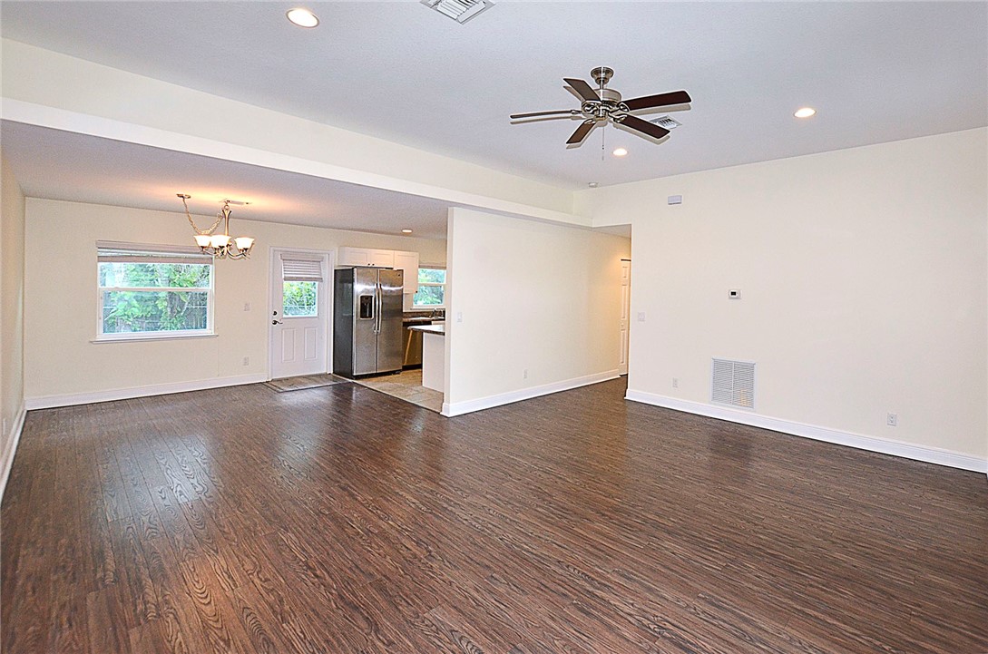 4899 Kirby Loop Road Fort Pierce, FL 34981 - Photo 5 of 32 a view of an empty room with a window and wooden floor