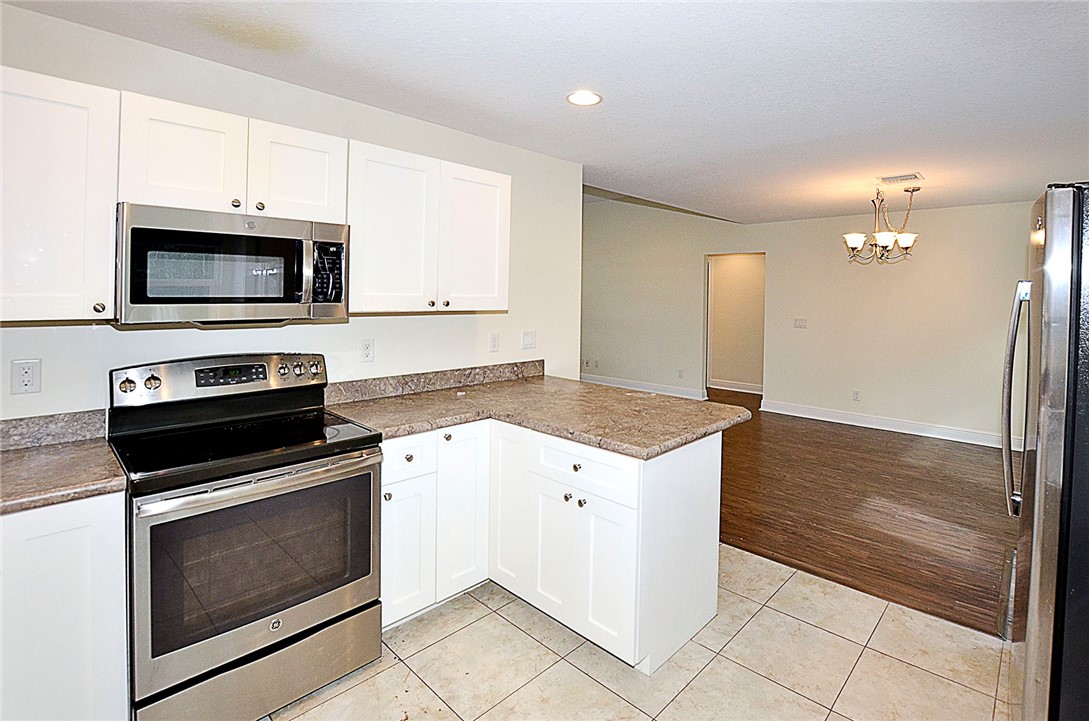 4899 Kirby Loop Road Fort Pierce, FL 34981 - Photo 9 of 32 a kitchen with a stove and a microwave
