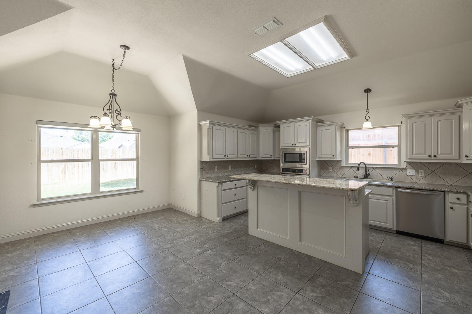 6406 93rd Street Lubbock, TX 79424 - Photo 11 of 40 a kitchen with a stove a sink dishwasher a refrigerator and white cabinets with wooden floor