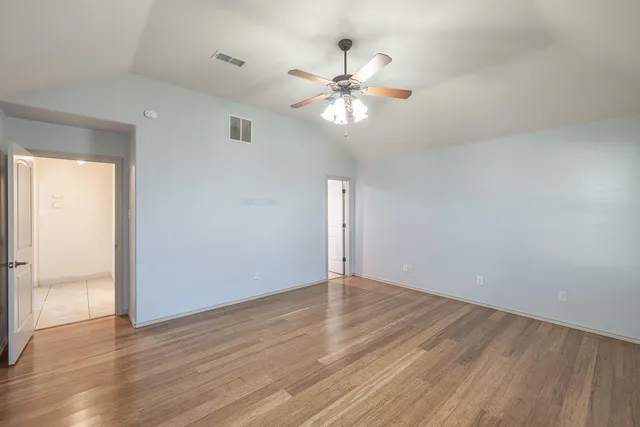 a view of an empty room with wooden floor