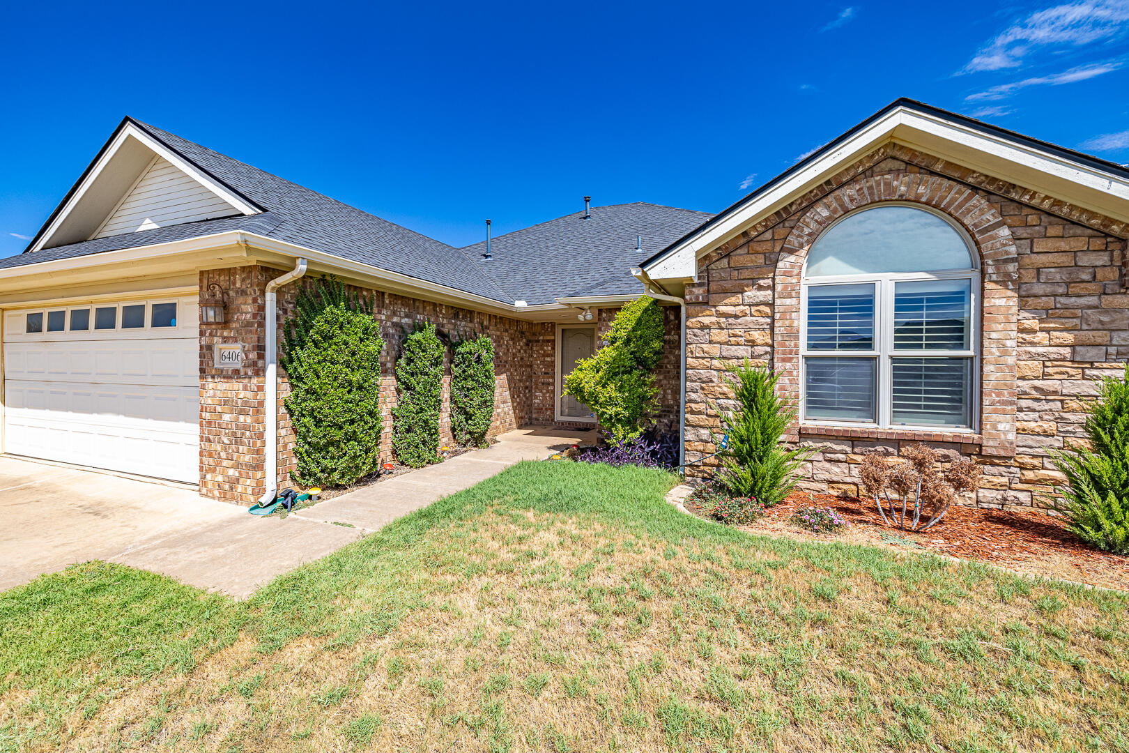 6406 93rd Street Lubbock, TX 79424 - Photo 2 of 40 a front view of a house with garden