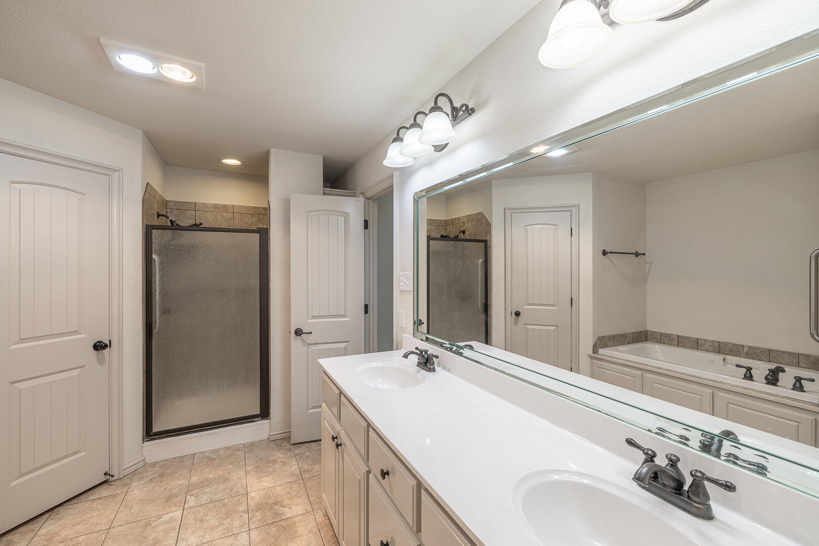 6406 93rd Street Lubbock, TX 79424 - Photo 24 of 40 a spacious bathroom with a double vanity sink mirror and shower