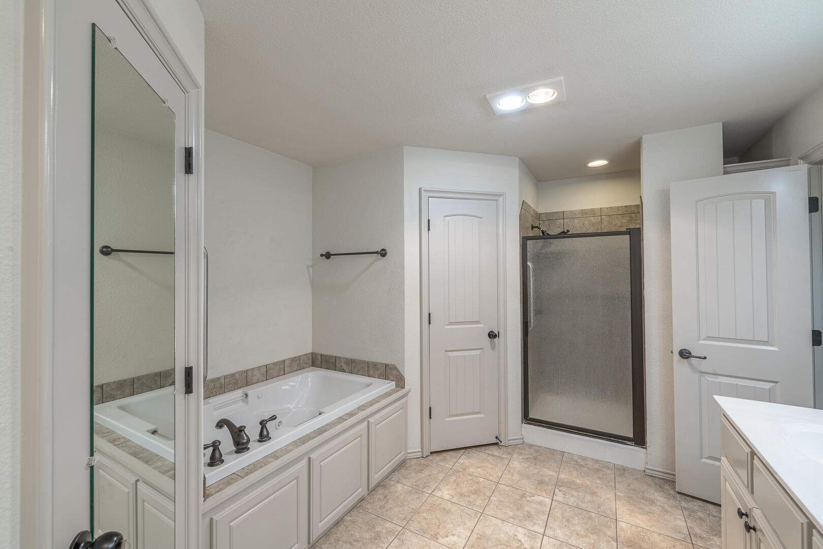 6406 93rd Street Lubbock, TX 79424 - Photo 25 of 40 a bathroom with a tub shower and mirror