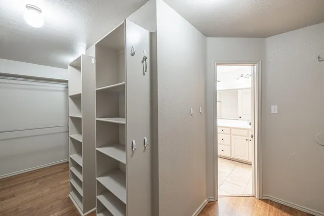 a view of walk in closet with empty racks