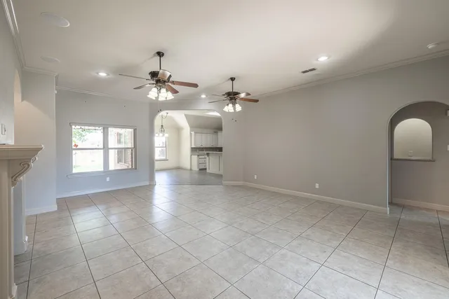 an empty room with a window and a fan