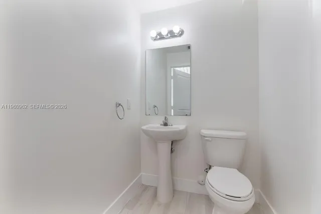 a bathroom with a toilet a sink and mirror