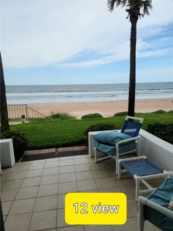 a view of a terrace with lawn chairs
