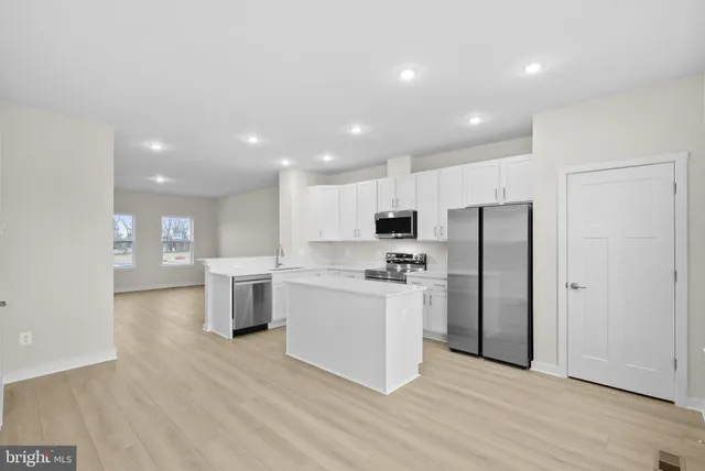 a kitchen with stainless steel appliances a refrigerator and a stove top oven