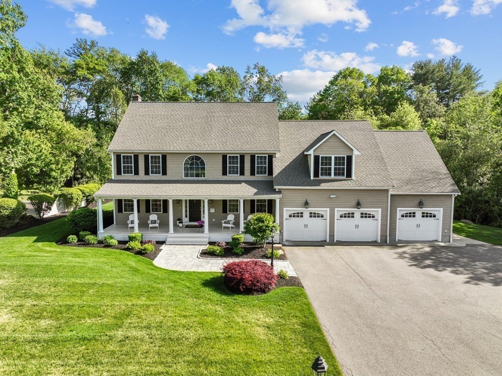 a front view of a house with yard and green space