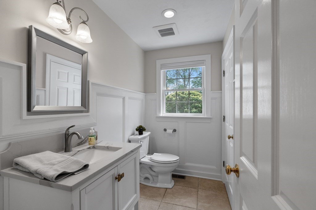 20 Walden Drive Walpole, MA 02081 - Photo 13 of 38 a bathroom with a granite countertop toilet a sink a mirror and a window