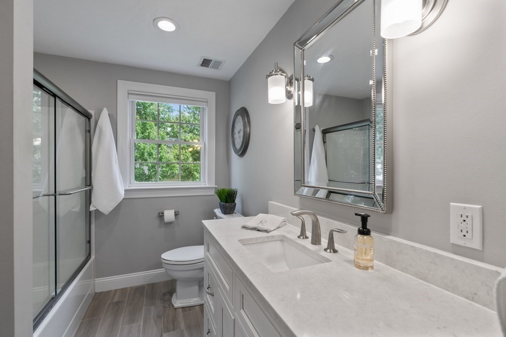 20 Walden Drive Walpole, MA 02081 - Photo 22 of 38 a bathroom with a granite countertop sink toilet a large mirror a vanity and window