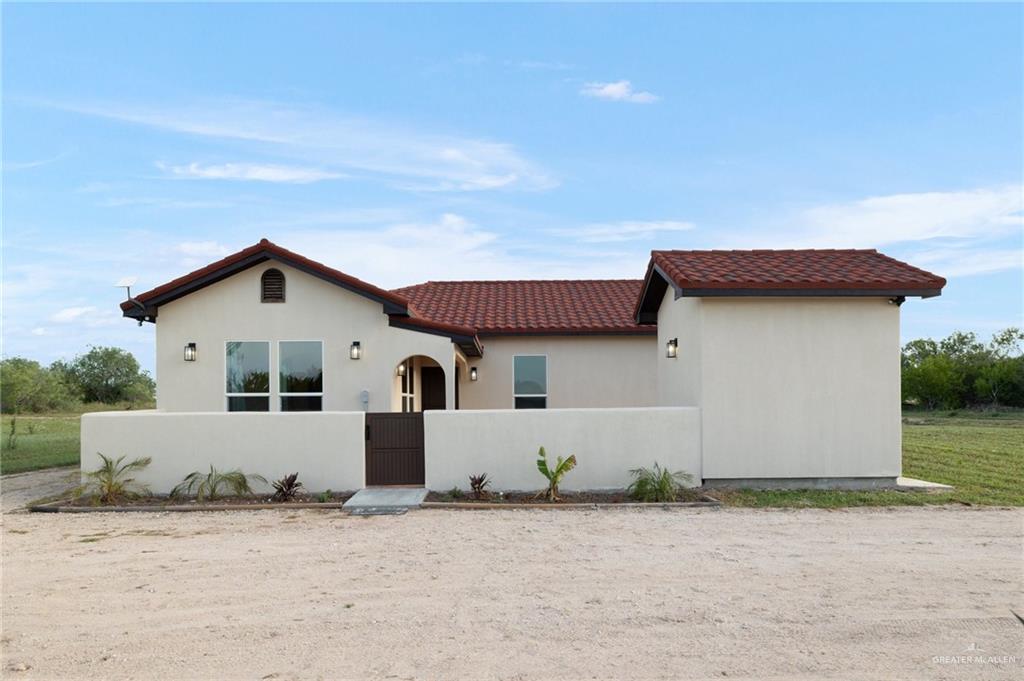 301 Pvt 755 Ranch Encino, TX 78353 - Photo 2 of 38 a front view of a house with a yard and garage