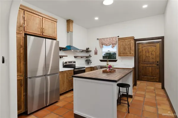 a kitchen with stainless steel appliances granite countertop a refrigerator and a sink