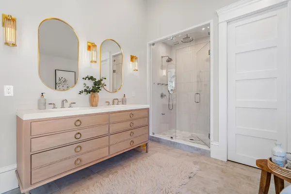 a bathroom with a double vanity sink mirror and shower