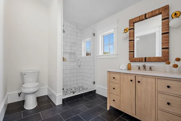 a bathroom with a granite countertop sink toilet a mirror and a shower