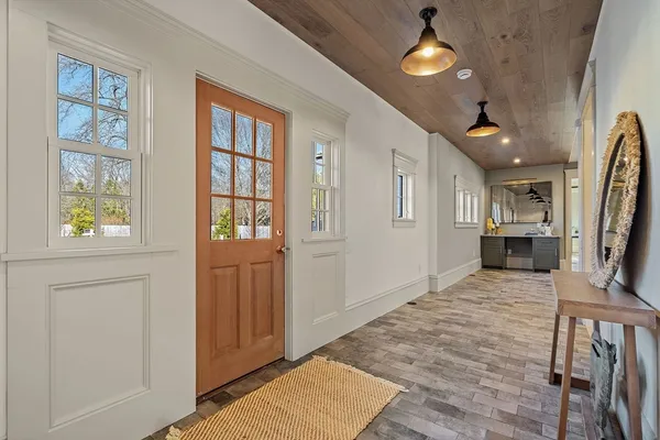 a view of a hallway with wooden floor and a kitchen