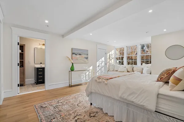 a bedroom with a bed and a dresser with wooden floor